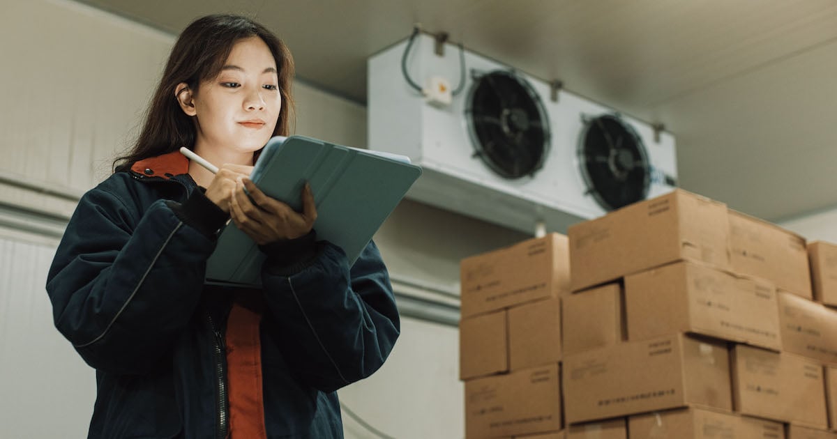 woman implementing continuous improvement practices in industrial refrigerated walk-in 